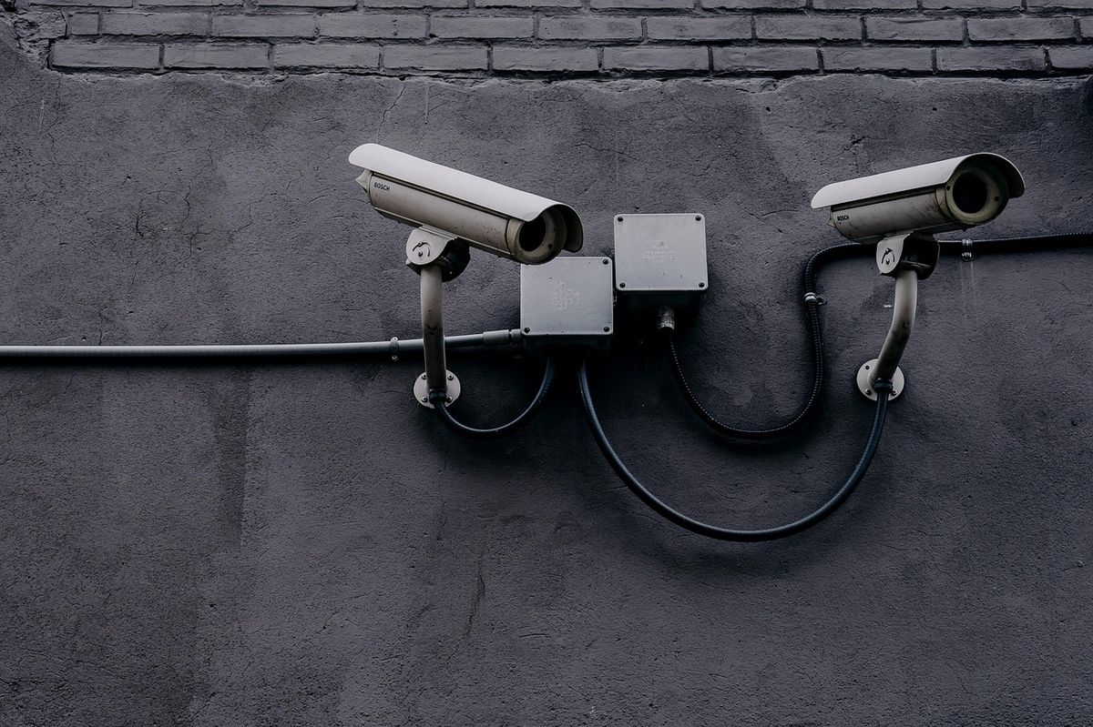 A small security camera mounted outdoors on a wall