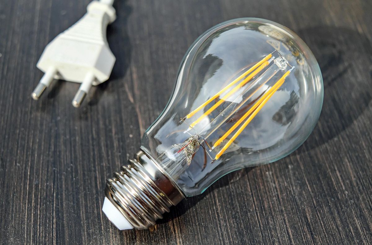 A light bulb sitting next to its plug, representing the kind of basic device most smart home apps are built to control
