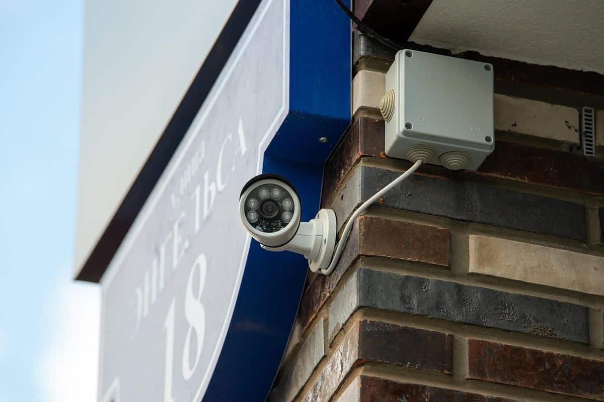 A security camera mounted on a building corner, illustrating outdoor camera placement in daylight and after dark