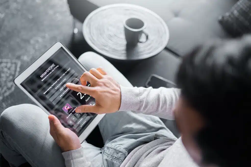 A man is using a tablet for his smart home.