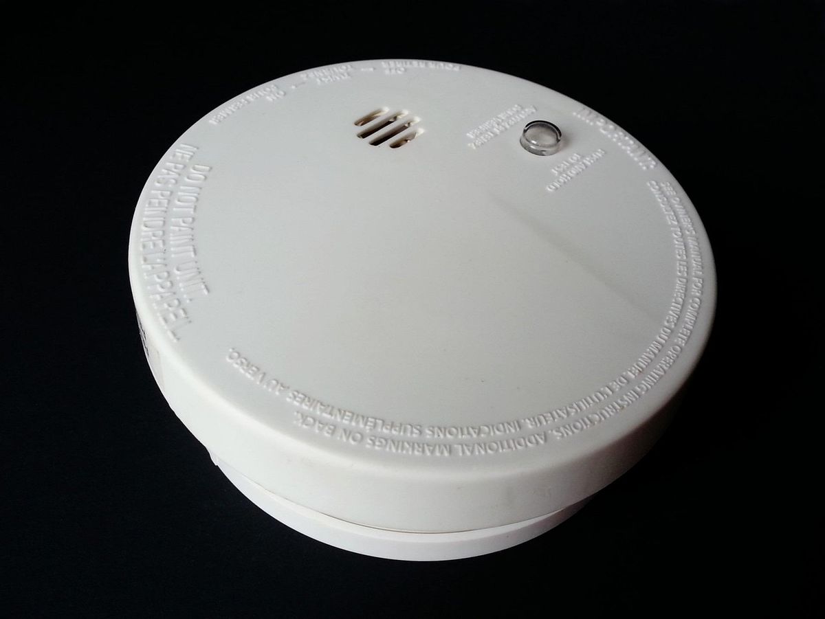 A round smoke detector unit, the kind of device mounted on a ceiling