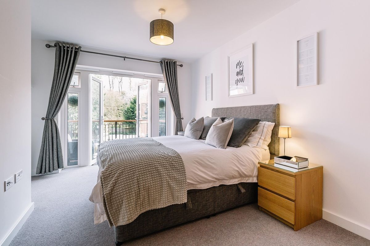 A modern bedroom interior, a room where a smoke or CO alarm is commonly installed nearby