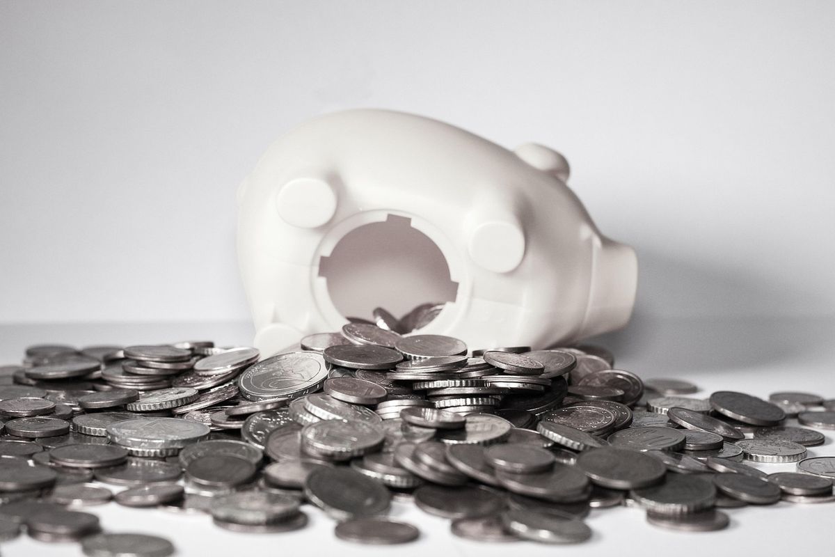 A piggy bank spilling coins, representing money saved by skipping a subscription