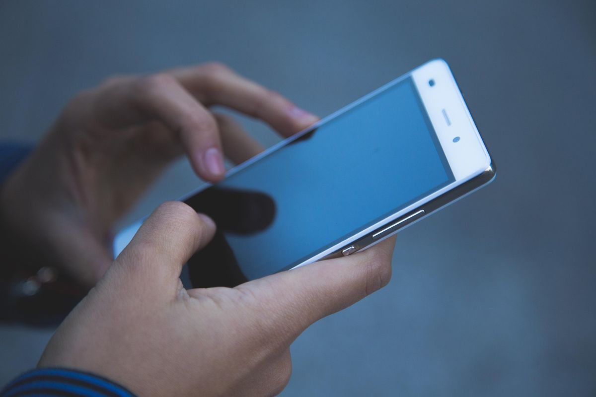 Hands holding and using a smartphone touchscreen