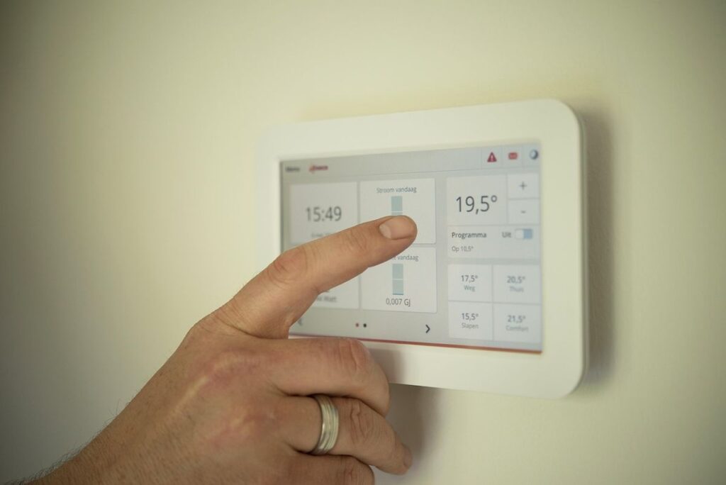 Person adjusting settings on a wall-mounted smart home control panel